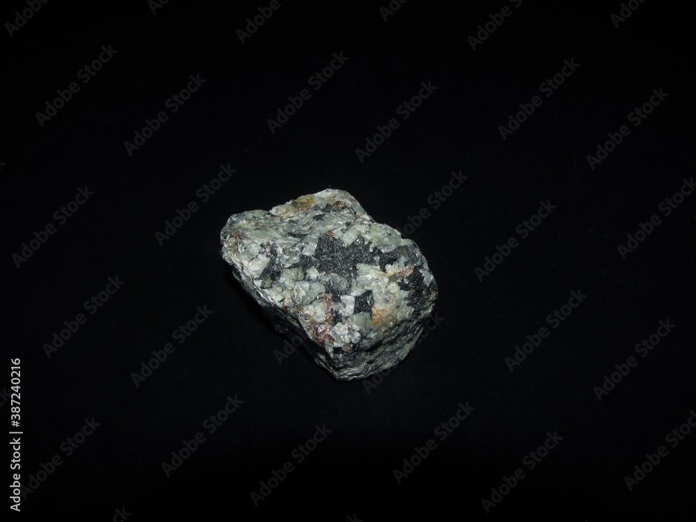 a sample of the urtite rock is gray-green on a black background a sample of the urtite rock is gray-green on a black background