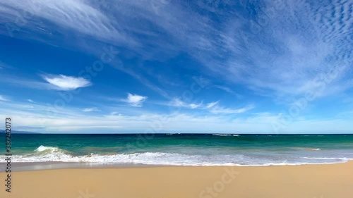 Beautiful sandy Hawaii beach with deep blue sky with wispy white clouds