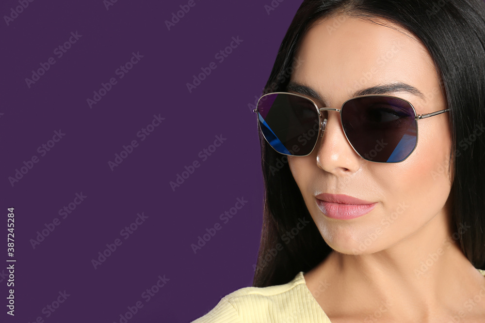 Beautiful woman wearing sunglasses on purple background, closeup. Space for text Beautiful woman wearing sunglasses on purple background, closeup. Space for text