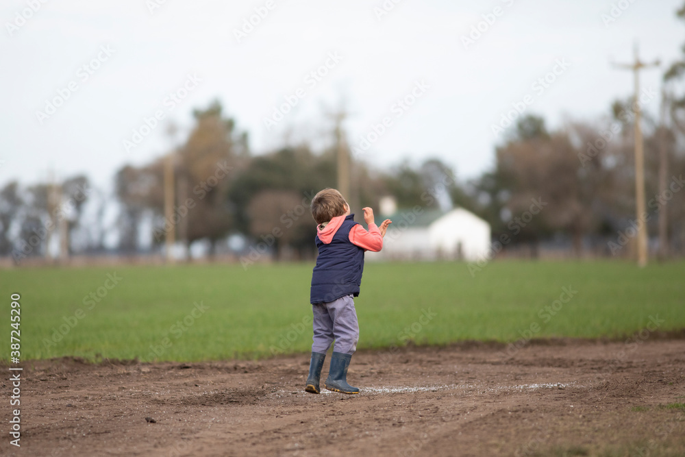 Niño jugando y corriendo por camino de tierra Niño jugando y corriendo por camino de tierra