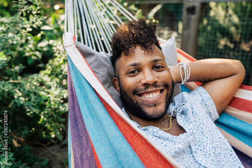 Portrait of smiling black man relaxing in hammock in back yard