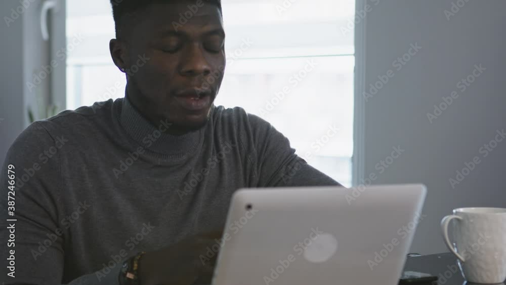 African american black man working on the laptop in his appartment. High quality 4k footage African american black man working on the laptop in his appartment. High quality 4k footage