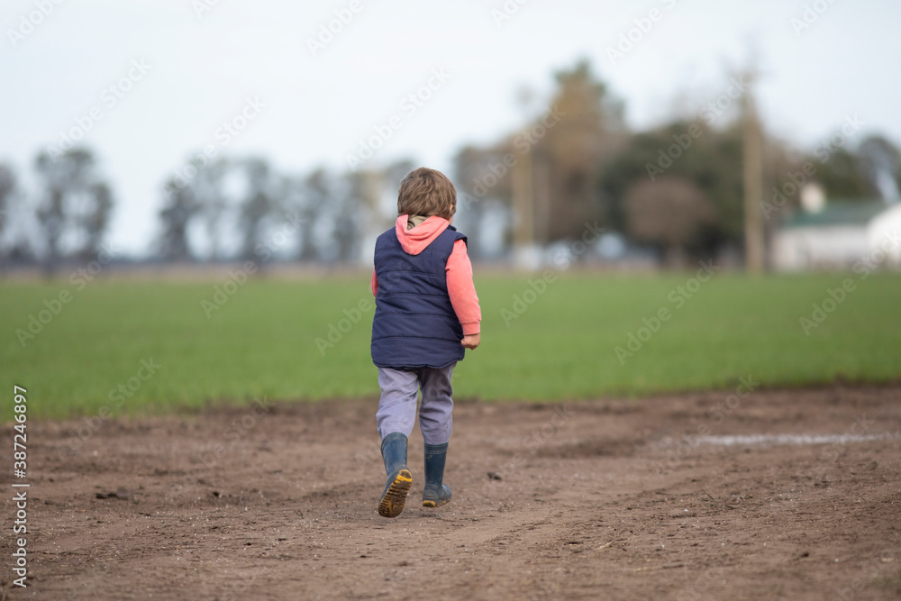 Niño jugando y corriendo por camino de tierra
