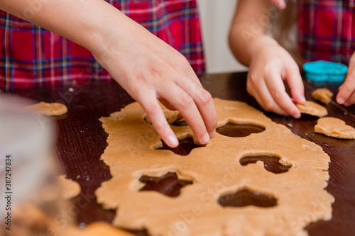 Two little girls cook at home in the kitchen ginger cookies for Christmas