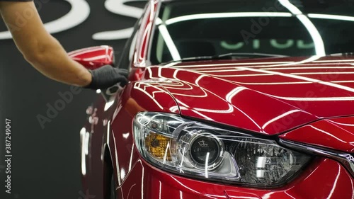 Car service worker applying nano coating on a car detail.