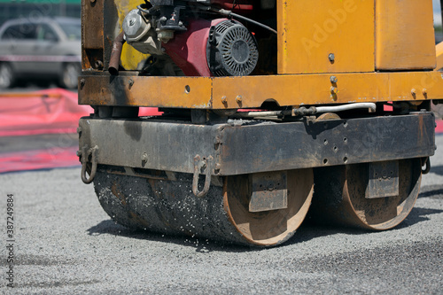 Small road roller during asphalt concrete pavement compaction repairing works 
