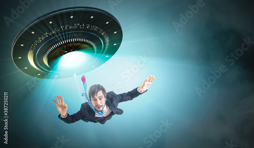 Konstfotografi Alien abduction concept. Young man is abducted by UFO.