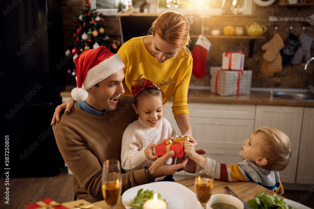 Happy family having fun while opening Christmas presents at home. Happy family having fun while opening Christmas presents at home.