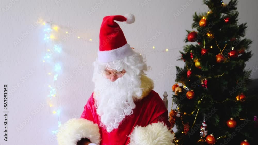 elderly santa claus with a white beard congratulates children and adults, holds banknotes in his hand, gives them, concept of christmas, holiday discounts, shopping, gifts elderly santa claus with a white beard congratulates children and adults, holds banknotes in his hand, gives them, concept of christmas, holiday discounts, shopping, gifts