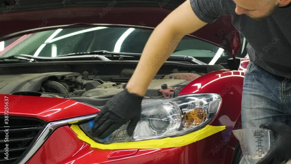 Headlight Polishing, processing of car lights. A car service worker polishes the headlight of a passenger car. Professional polishing. Headlight Polishing, processing of car lights. A car service worker polishes the headlight of a passenger car. Professional polishing.