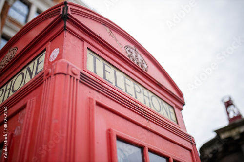 Close up of the top of a London telephone booth with a bright sky over it