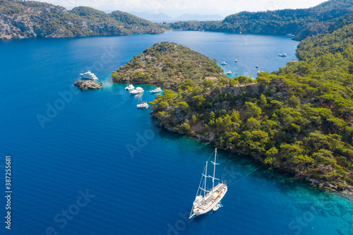 close up aerial view to sailing yachts and coastline with boats in bay under sky