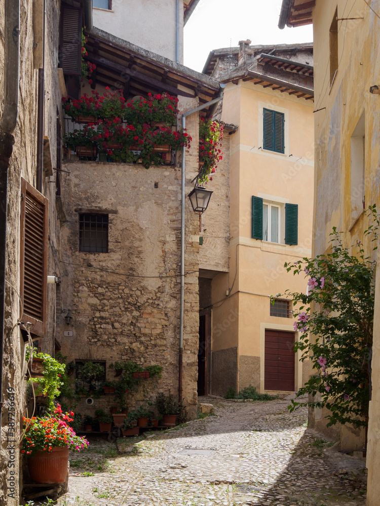 Rincones de paisaje urbano de la ciudad de Spoleto, con fachadas y flores, en Italia, verano de 2019.