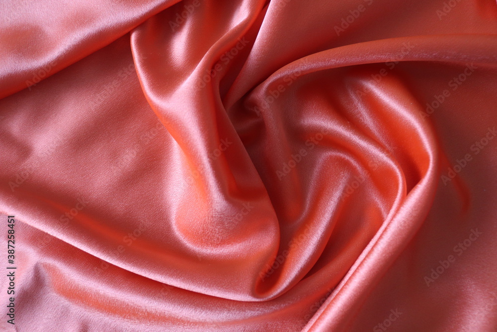 Obraz premium Smooth elegant coral silk or satin fabric. Draped luxury cloth texture for design. Close-up