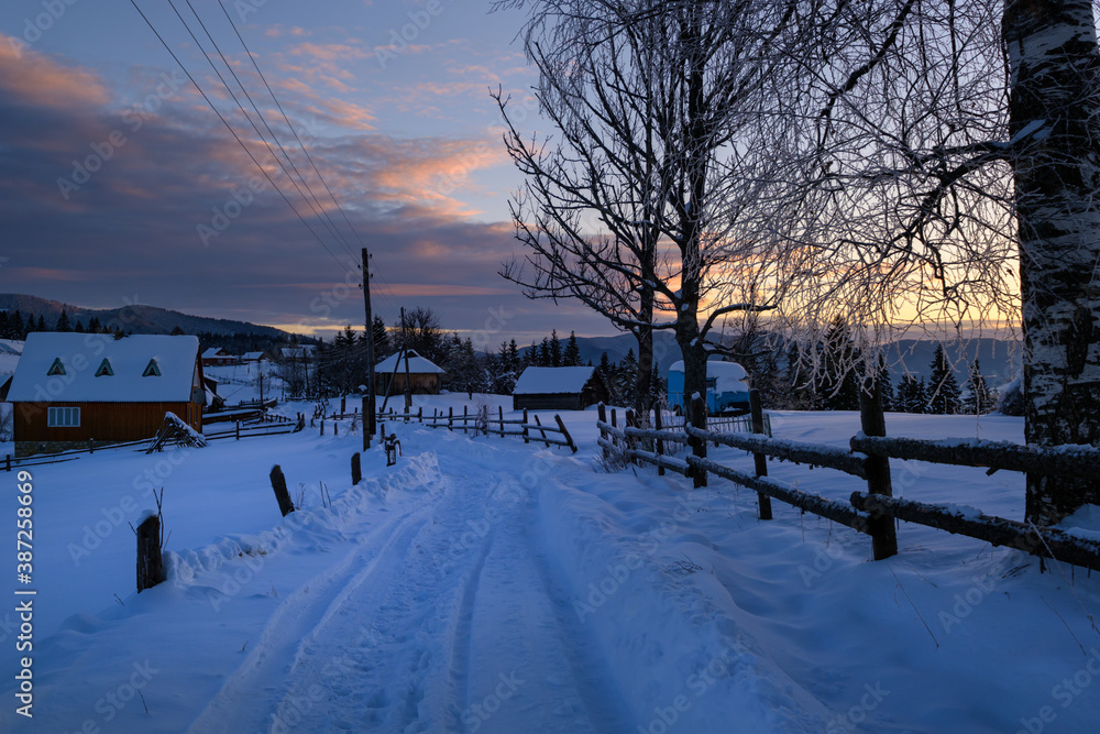 Small and quiet alpine village and winter sunrise snowy mountains around, Voronenko, Carpathian, Ukraine.