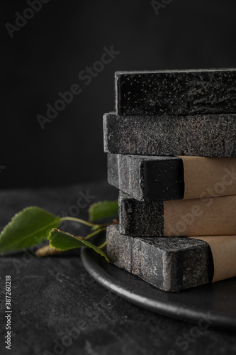 Fototapeta Naklejka Na Ścianę i Meble -  Stack of natural tar soap on black table, closeup
