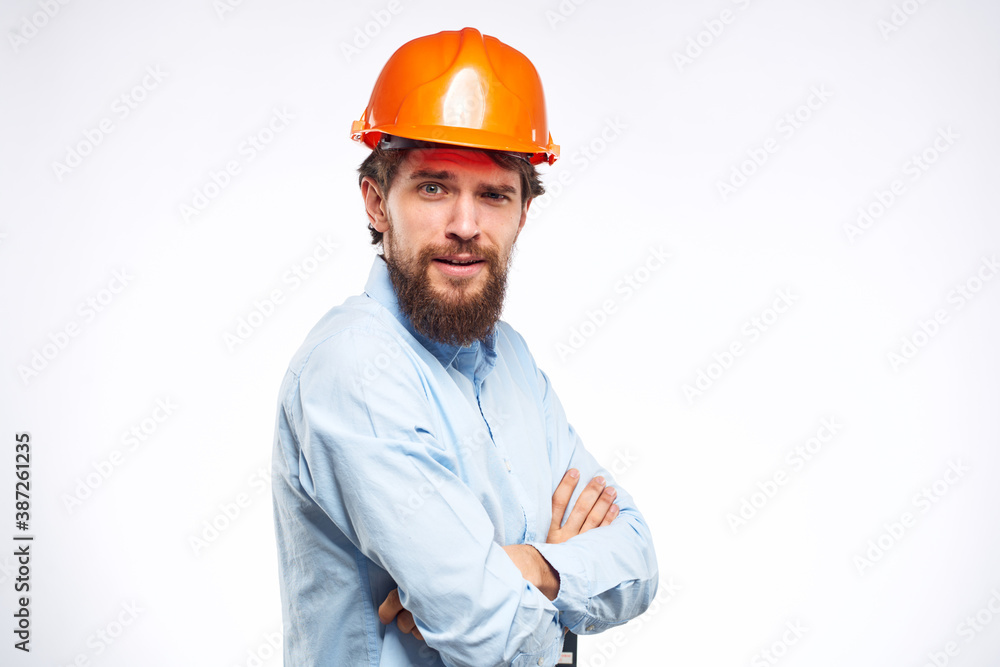 Cheerful man orange hard hat work industry professional lifestyle light background Cheerful man orange hard hat work industry professional lifestyle light background