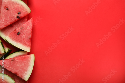 Slices of ripe watermelon on red background, flat lay. Space for text