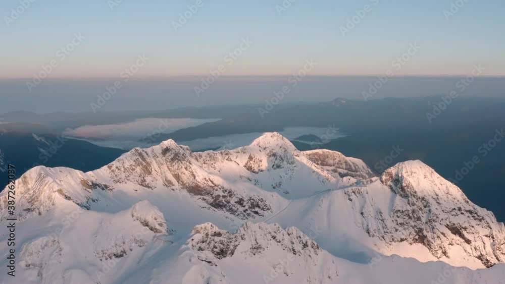 Ski snowy resort peak at amazing pink sunrise aerial view second and third circus on top of Black Pyramid mountain at Sochi Krasnaya Polyana. Sea and clouds background