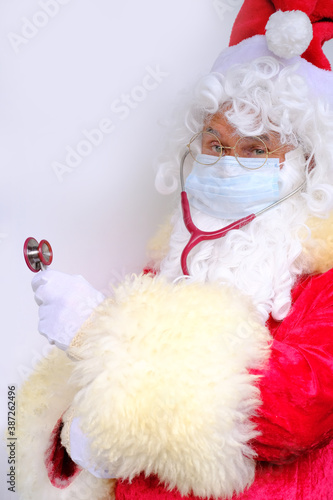 male doctor, santa claus with a white beard, medical stethoscope, concept of christmas, waiting for gifts, preventive examination, treatment people from covid-19