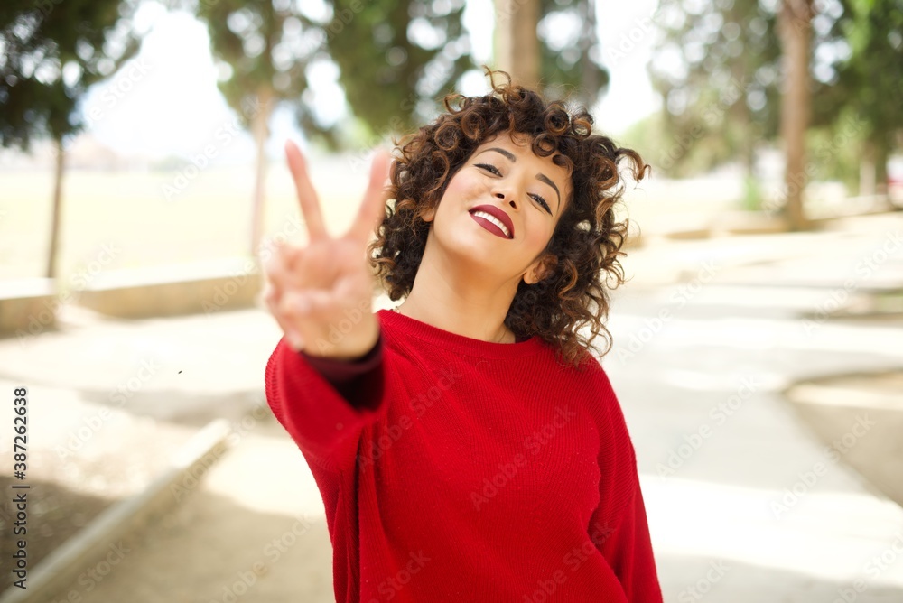 Φωτογραφία Young arab woman wearing casual red sweater in the street directs fingers at camera selects someone