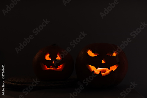 Halloween pumpkin head lantern on black background. Jack-o-lantern carved pumpkins for Halloween. Halloween pumpkin with eyes glowing inside at black background. idea for halloween 2020