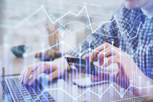 Double exposure of man hands holding a credit card and Forex graph drawing. Stock trading and digital fintech in Internet E-commerce concept.