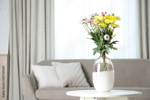 Vase with beautiful flowers on table in living room  space for text. Stylish element of interior design