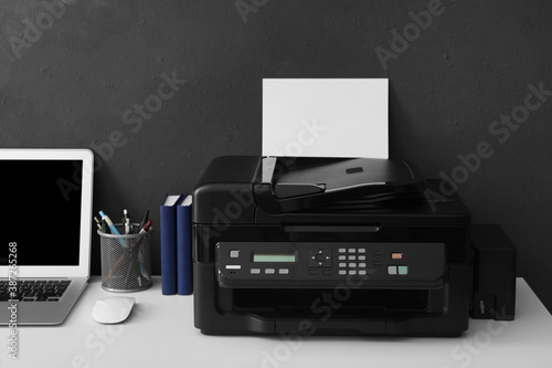 New modern printer, laptop and office supplies on white table