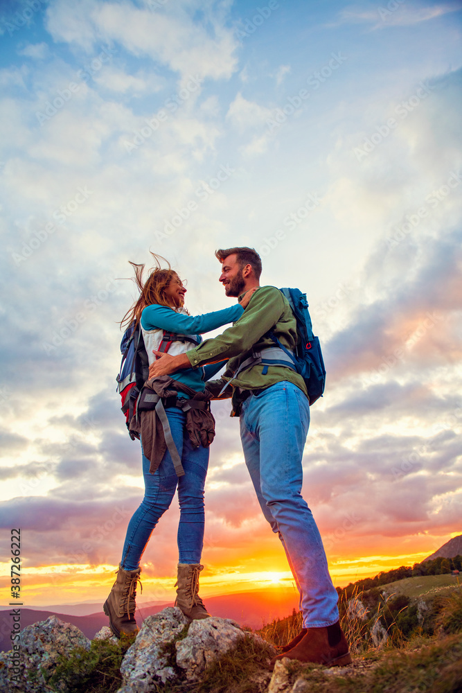 Couple on Top of a Mountain Hugging and enjoying view.