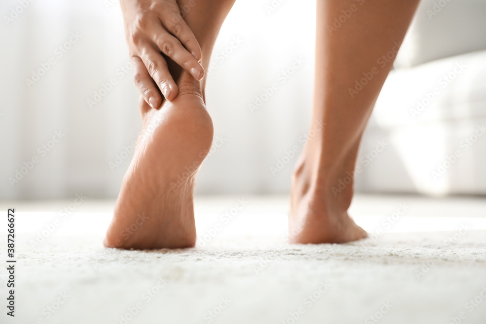 Young woman suffering from pain in foot indoors, closeup Young woman suffering from pain in foot indoors, closeup