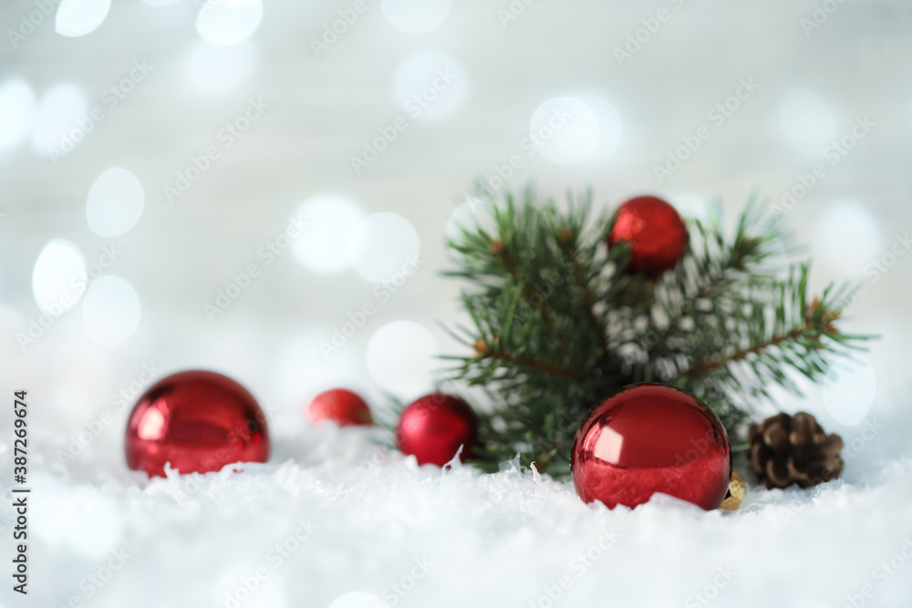 Beautiful red Christmas balls and fir tree branch on snow, bokeh effect Beautiful red Christmas balls and fir tree branch on snow, bokeh effect