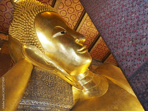 Close up of the Reclining Buddha gold statue's face, Wat Pho, Bangkok, Thailand