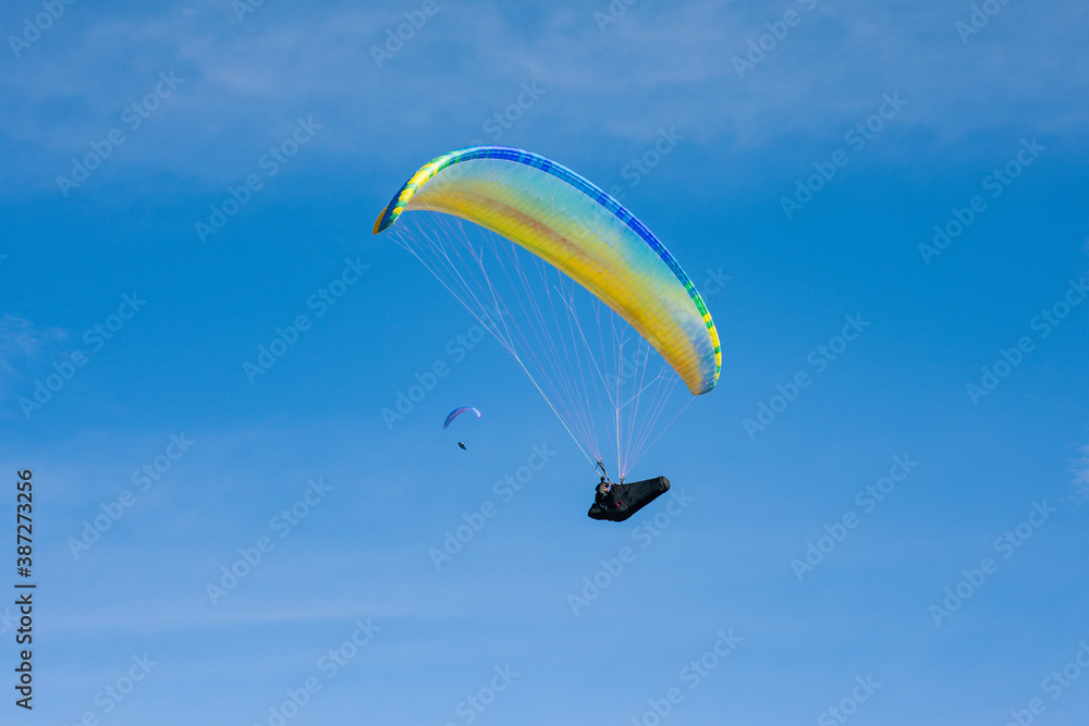 Colourful paraglider on a blue sky background. Extreme sport. Crazy hobby. Colourful paraglider on a blue sky background. Extreme sport. Crazy hobby.