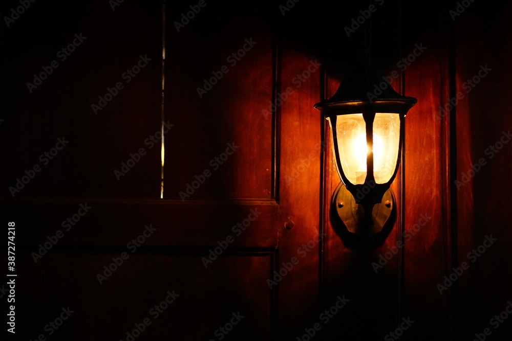 Classic lamp on wooden wall. The light is yellow Classic lamp on wooden wall. The light is yellow