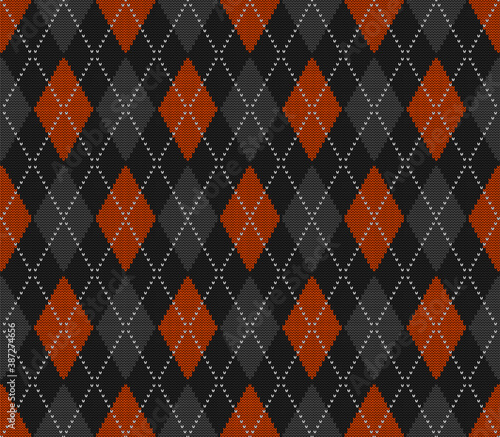 Knitted argyle Halloween pattern. Wool knitinng. Scottish plaid in orange, black and grey rhombuses. Traditional  Scottish background of diamonds . Seamless fabric texture. Vector illustration photo