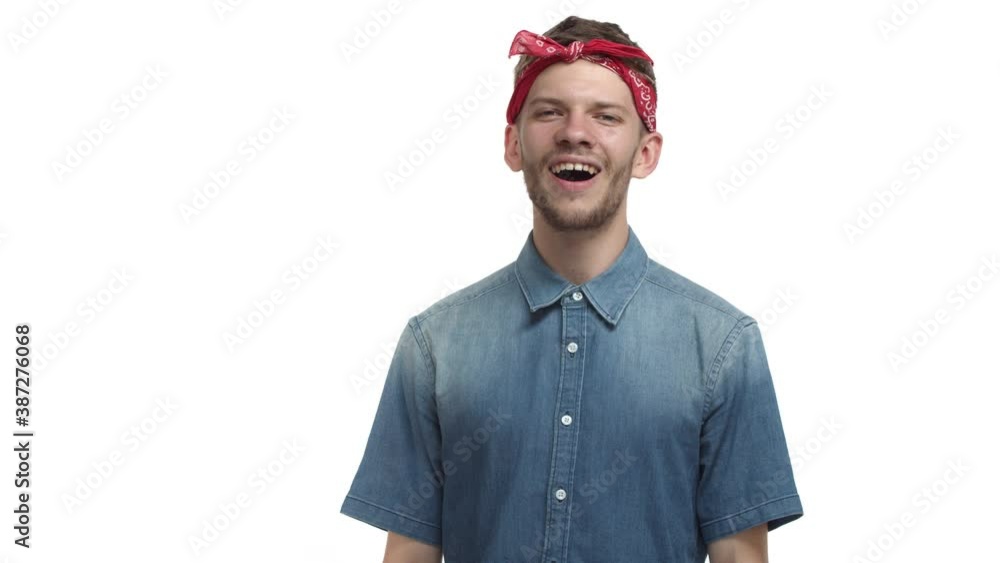 Handsome bearded hipster guy with red hip hop bandana, looking confused and frowning, then begin to understand and nodding in approval, smiling pleased, standing over white background Handsome bearded hipster guy with red hip hop bandana, looking confused and frowning, then begin to understand and nodding in approval, smiling pleased, standing over white background