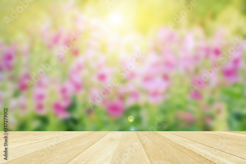 Empty top wooden table on blurred pink flowers in park