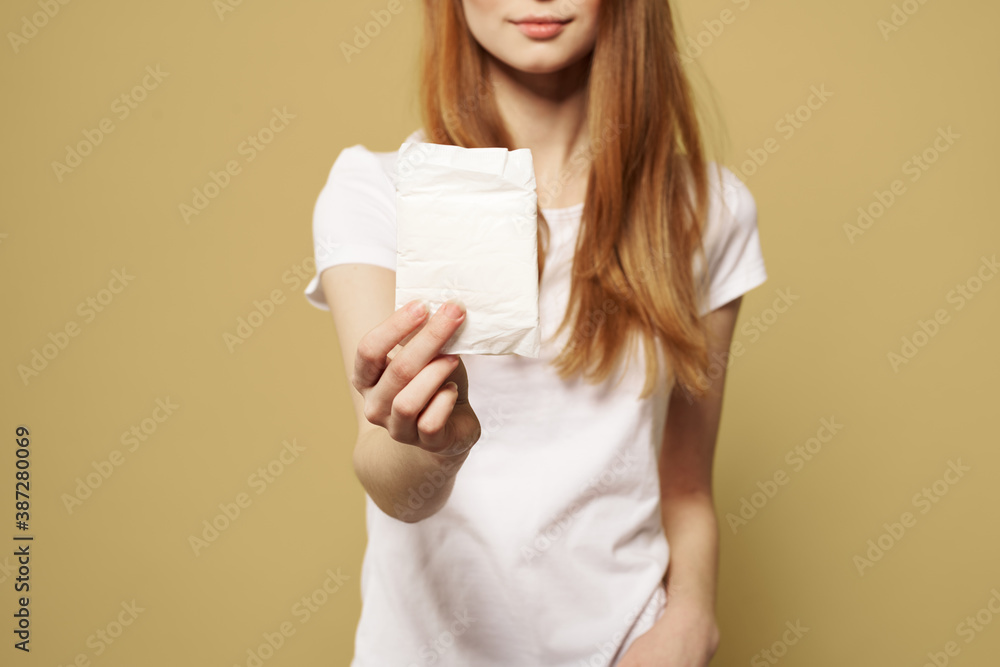 Girl with pad on beige background menstruation critical days cropped view of white t-shirt Girl with pad on beige background menstruation critical days cropped view of white t-shirt