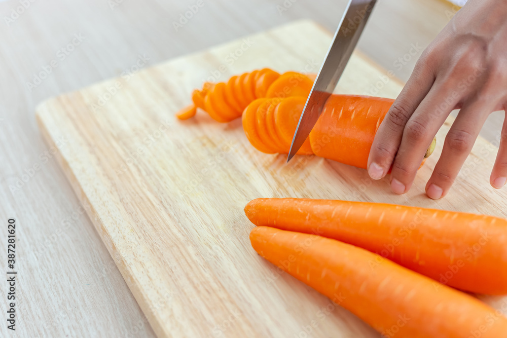 Fresh carrot and cut pieces on wooden cutting board - obrazy, fototapety, plakaty 