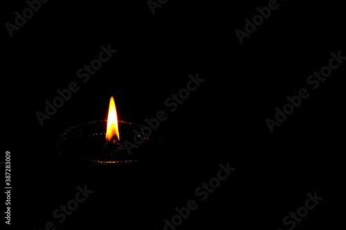 Flame of clay oil lamp in the dark.