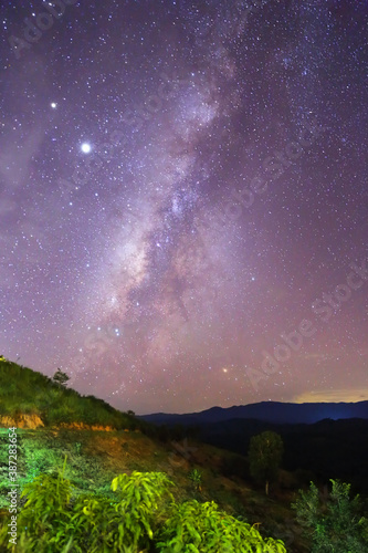 A beautiful night view of the trees and the Milky Way galaxy on the mountain in Nan province of Thailand. Image selective focus background