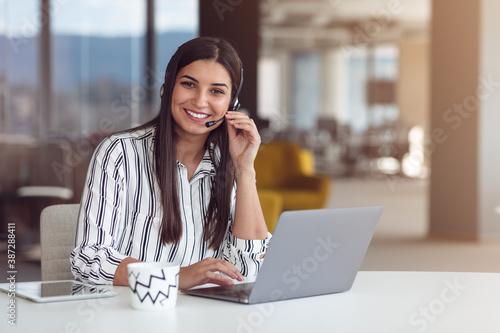 Portrait of focused woman in headphones taking part in webinar in office