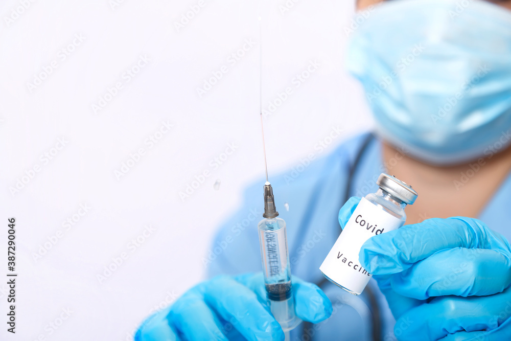 A vial with a vaccine for the prevention of a virus in the hands of a doctor and a syringe. A vial with a vaccine for the prevention of a virus in the hands of a doctor and a syringe.