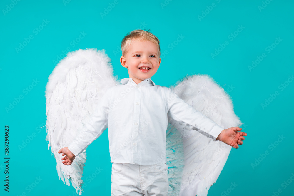 Kids with angel wings. Little cute boy child in angel dress with happy smiling face. Cupid valentin on valentines day. Festive greeting love Card. Kids with angel wings. Little cute boy child in angel dress with happy smiling face. Cupid valentin on valentines day. Festive greeting love Card.