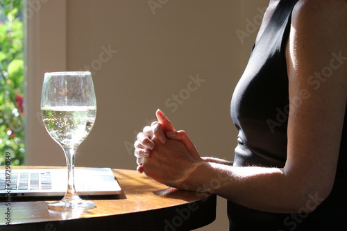 Vászonkép Mature woman in home office with laptop and grubby wine glass of white wine