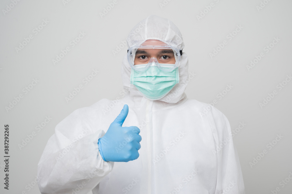 A portrait of virologist Wearing PPE suit get thumb up and look into cabers isolated on white background. Personal Protective Equipment Concept.. A portrait of virologist Wearing PPE suit get thumb up and look into cabers isolated on white background. Personal Protective Equipment Concept..