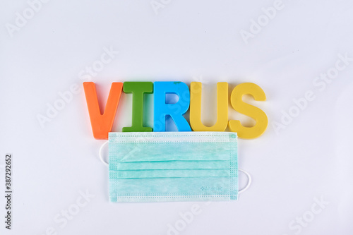 Health, safety and pandemic concept, virus alphabets color sign paired with medical mask for campaign pretection from virus disease. photo