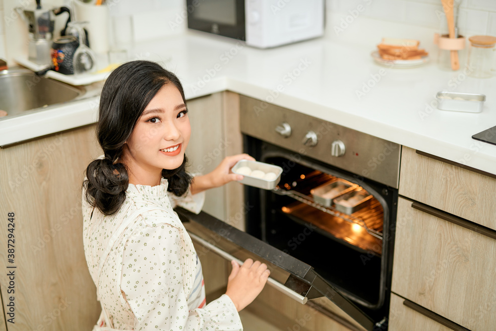 Woman put cookies in stove Woman put cookies in stove