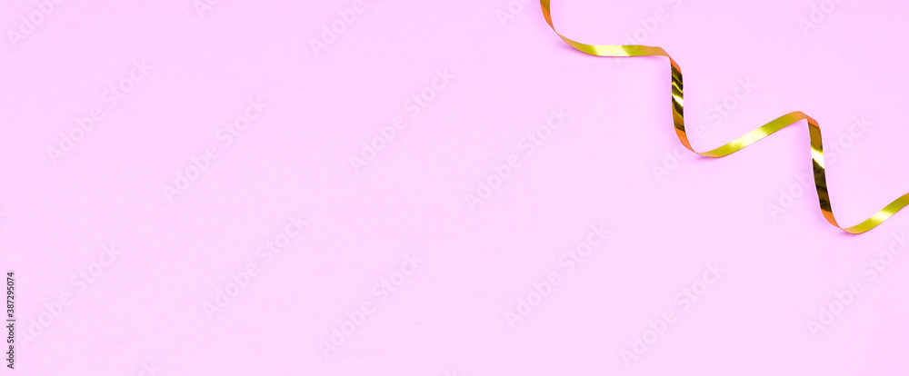 Golden ribbons isolated on pastel pink background Golden ribbons isolated on pastel pink background